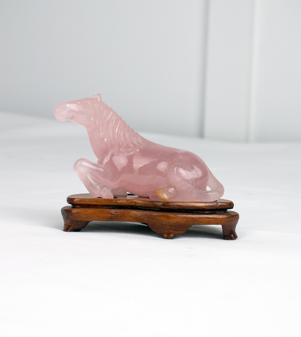 Cavall de quarz rosa sobre peana de fusta
