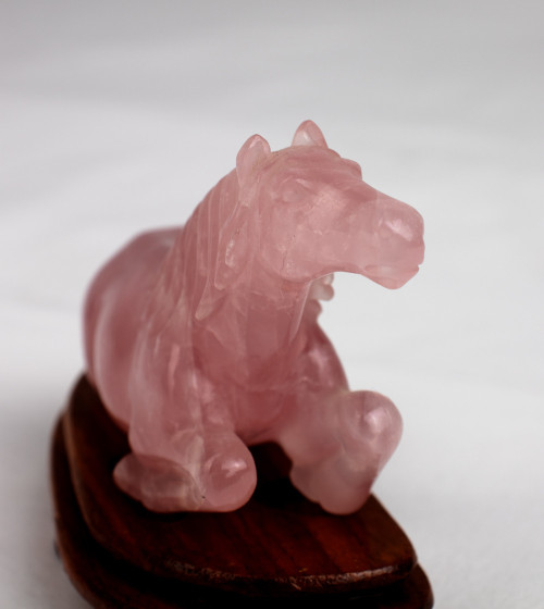 Cavall de quarz rosa sobre peana de fusta