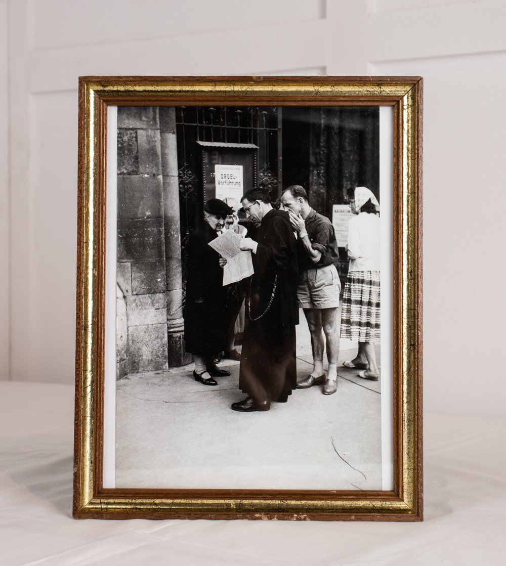 Black and white framed photo with priest